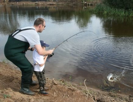 Peter Walls helps his son Ronan land a trout at the Open Day